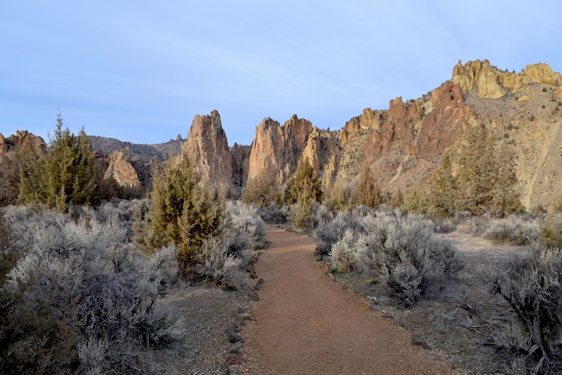 The Homestead Trail in Smith Rock State Park is one of Central Oregon's beautiful but easy hikes. Walk in Oregon's High Desert among the red rocks, cliffs and spires of this underrated state park. An excellent day trip from Bend, Oregon! To & Fro Fam